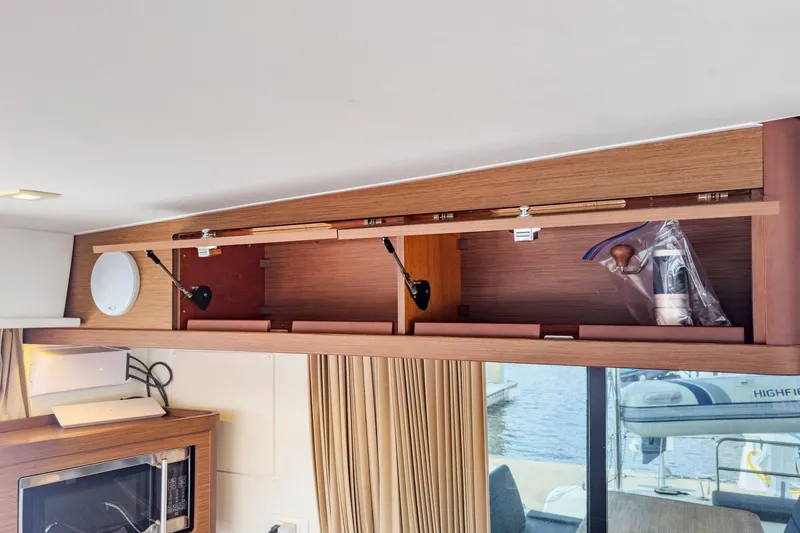 Slide: The Image of Interior storage of 2020 Lagoon 42 catamaran with open wooden cabinets. - 30