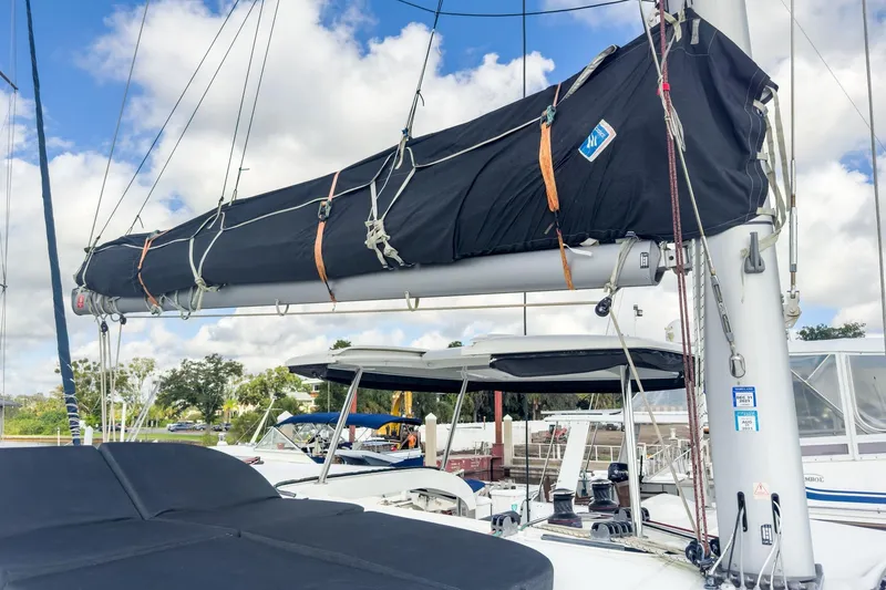 Slide: The Image of 2020 Lagoon 42 sailboat with covered boom, docked under a partly cloudy sky. - 21
