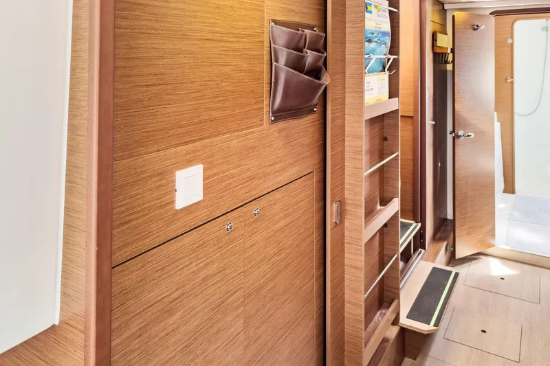 Slide: The Image of Interior of 2020 Lagoon 42 yacht featuring wooden cabinetry and open door to bathroom. - 48
