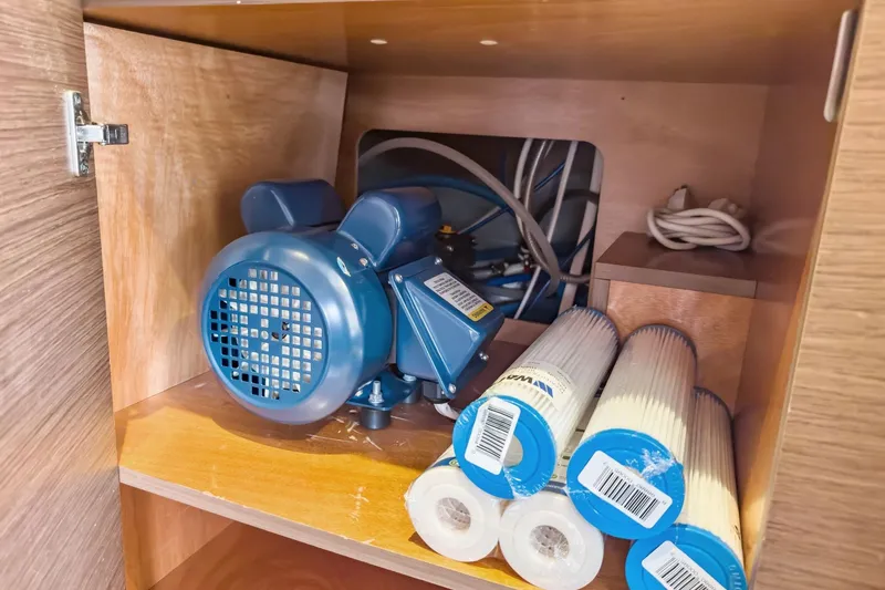 Slide: The Image of Storage compartment with blue motor and filters in 2020 Lagoon 42 yacht. - 72