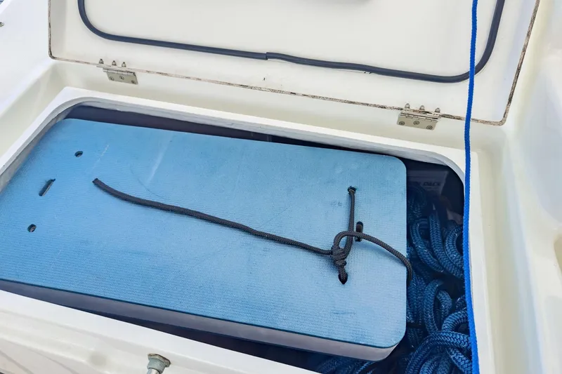 Slide: The Image of Open storage compartment on Lagoon 42 yacht, featuring blue ropes and a secured mat. - 79