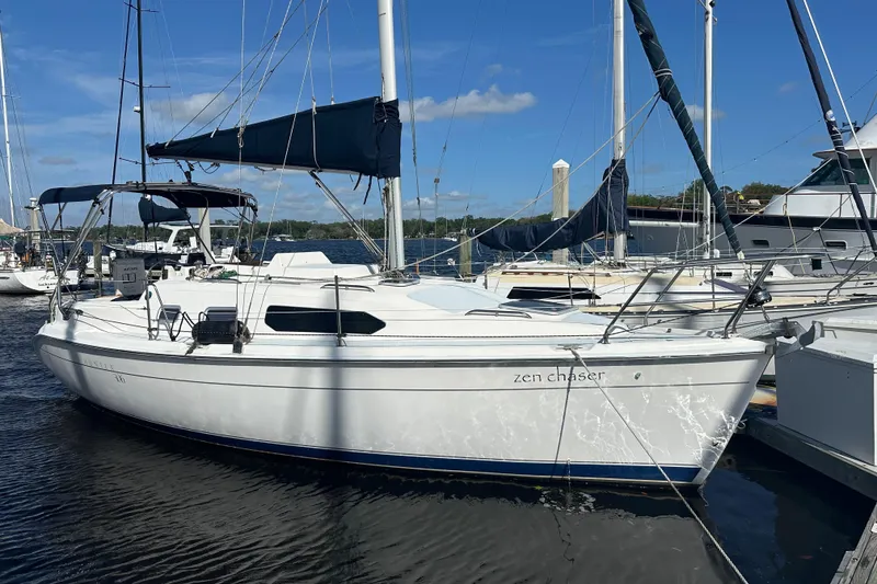The Image of 2002 Hunter 306 sailboat docked at marina under clear blue sky. - 1