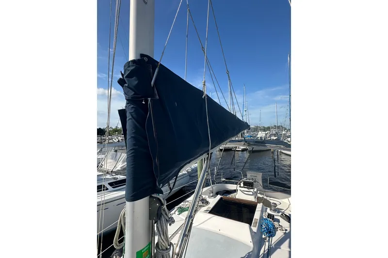Slide: The Image of Sailboat Hunter 306 (2002) with covered mainsail in marina, clear blue sky. - 10
