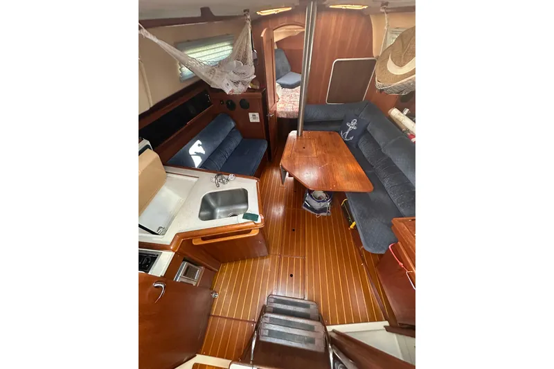 Slide: The Image of Interior of 2002 Hunter 306 sailboat with wood flooring and cozy seating area. - 16