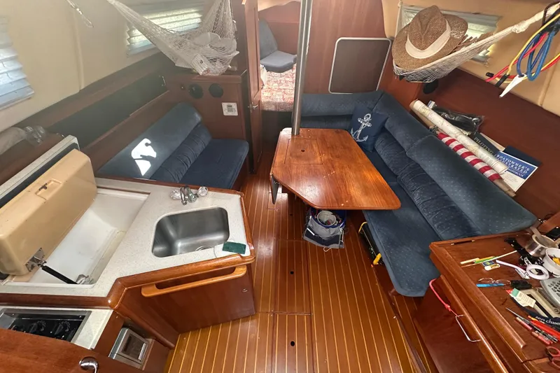 Slide: The Image of Interior of a 2002 Hunter 306 sailboat with cozy seating and compact kitchen area. - 17
