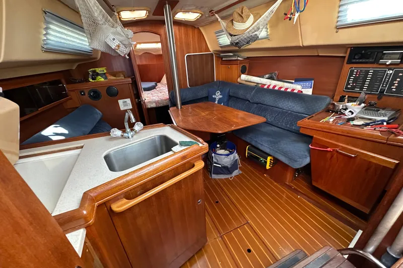 Slide: The Image of Interior of a 2002 Hunter 306 sailboat with wooden furnishings and a compact kitchen area. - 19