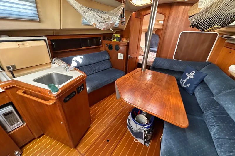 Slide: The Image of Interior of a 2002 Hunter 306 sailboat with cozy seating and wooden table. - 20