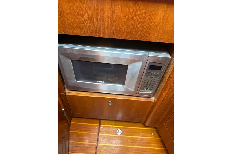 Slide: The Image of Microwave in wooden cabinet on 2002 Hunter 306 boat interior. - 23