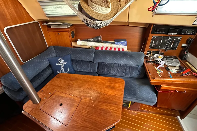 Slide: The Image of Interior of a 2002 Hunter 306 sailboat with blue seating and wooden table. - 26
