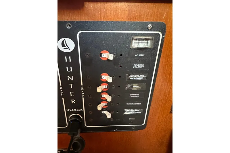 Slide: The Image of Electrical panel of a 2002 Hunter 306 sailboat with labeled switches and controls. - 28