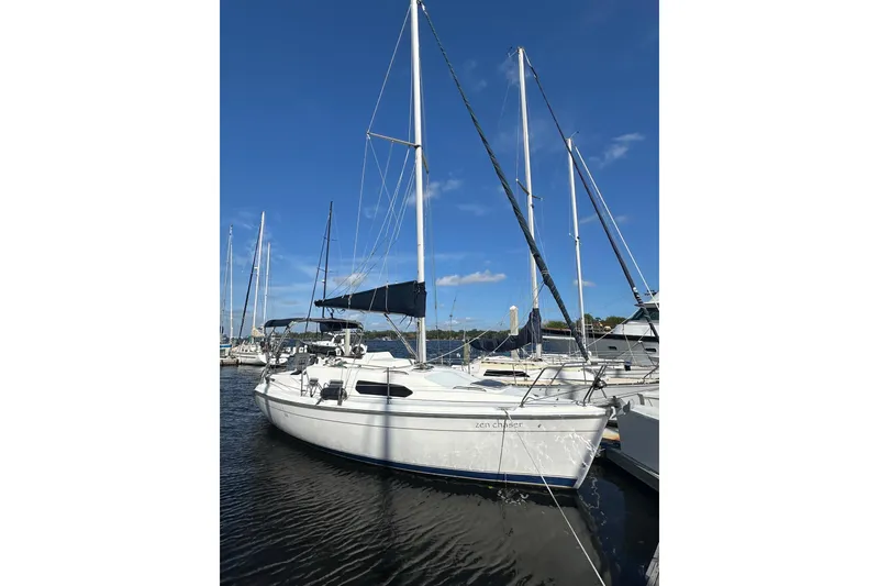 Slide: The Image of 2002 Hunter 306 sailboat docked in marina under clear blue sky. - 3