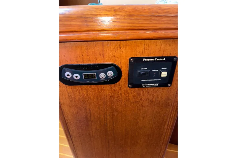 Slide: The Image of Control panel on a 2002 Hunter 306 boat, featuring propane and temperature controls. - 37