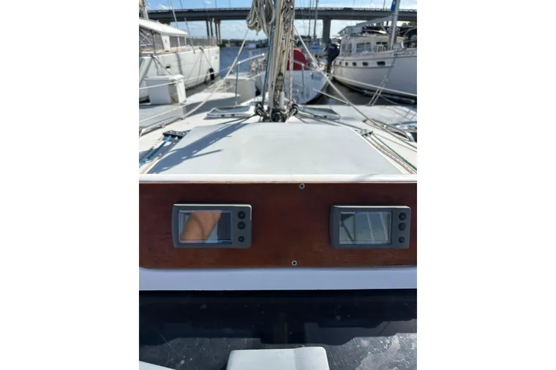 Slide: The Image of 2002 Hunter 306 sailboat deck with navigation instruments, docked in a marina. - 38