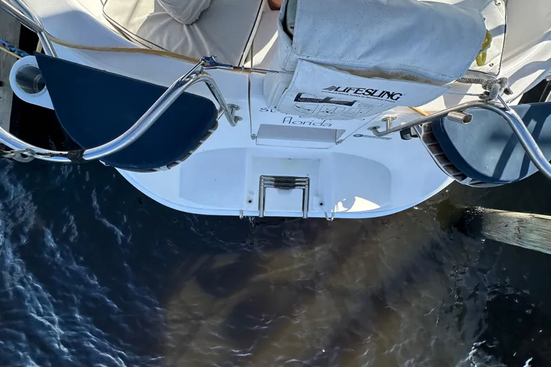 Slide: The Image of Hunter 306 sailboat stern view, featuring Lifesling and docked in Florida waters. - 39