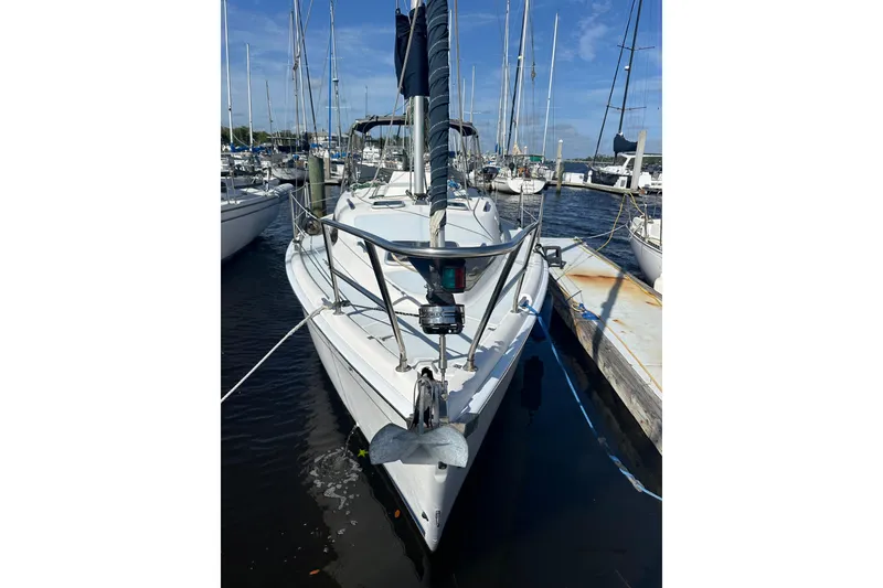 Slide: The Image of 2002 Hunter 306 sailboat docked at marina under clear blue sky. - 4
