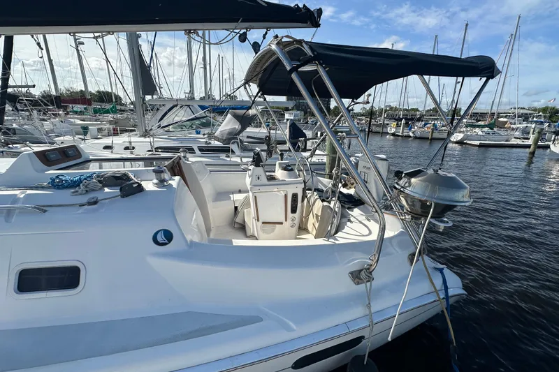 Slide: The Image of 2002 Hunter 306 sailboat docked at marina, featuring cockpit and canopy. - 6