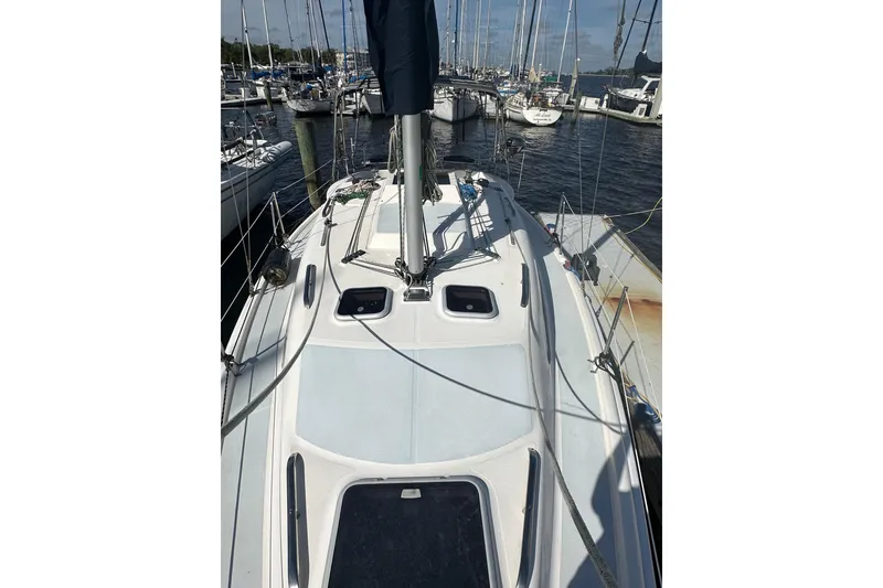 Slide: The Image of 2002 Hunter 306 sailboat docked at marina, view of deck and mast. - 9