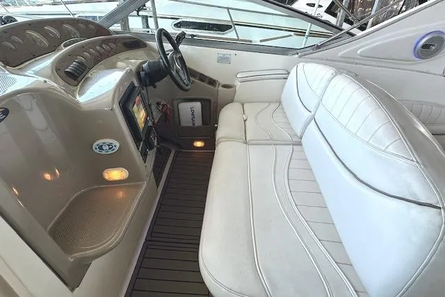 Slide: The Image of 2001 Maxum 3000 SCR boat interior with steering wheel, dashboard, and white seating. - 11