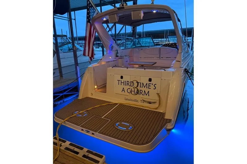 Slide: The Image of 2001 Maxum 3000 SCR boat docked, displaying "Third Time's a Charm" with blue underwater lights. - 2