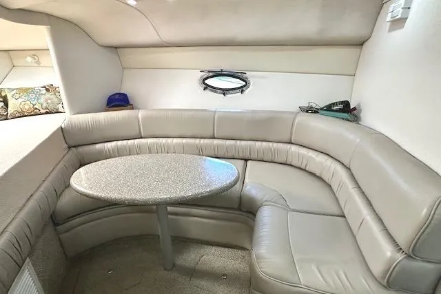 Slide: The Image of Interior of 2001 Maxum 3000 SCR boat with curved seating and round table. - 21