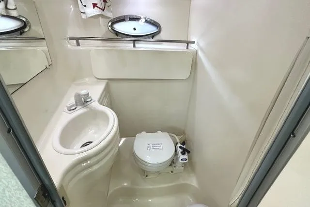 Slide: The Image of 2001 Maxum 3000 SCR boat bathroom with sink, toilet, and mirror. - 26