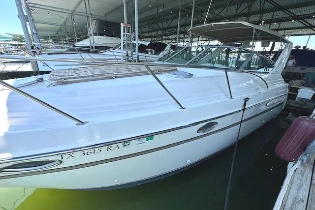 Slide: The Image of 2001 Maxum 3000 SCR boat docked in a marina under a covered structure. - 5