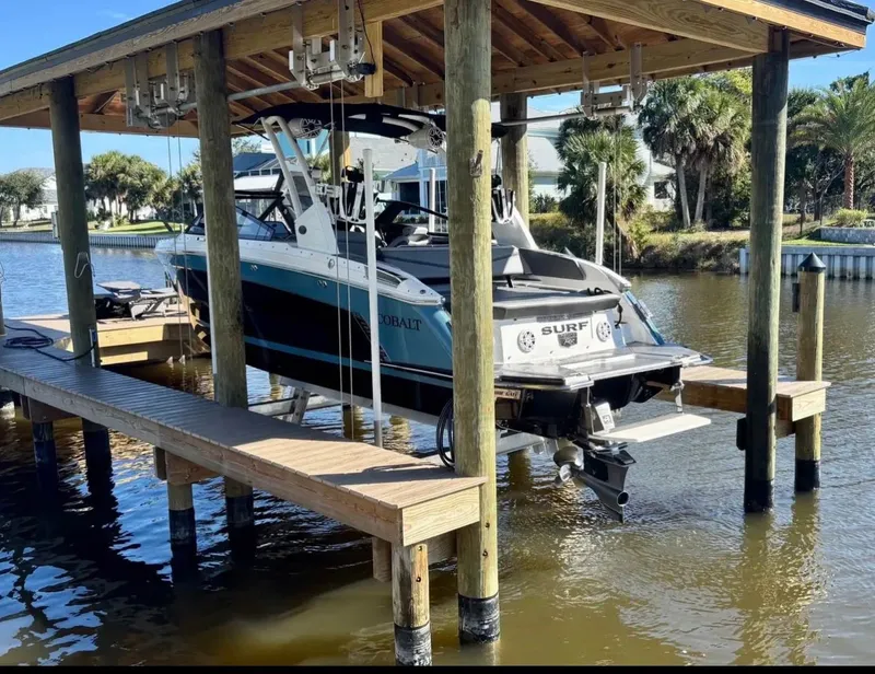 Slide: The Image of 2024 Cobalt R6SURF boat on a covered boat lift. - 2