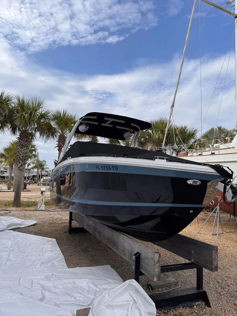 Slide: The Image of 2024 Cobalt R6SURF boat on a stand, surrounded by palm trees. - 8