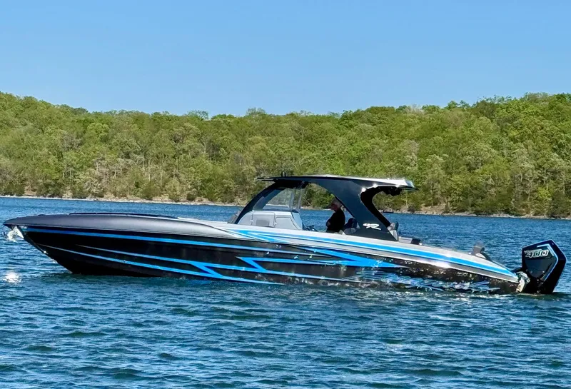 Slide: The Image of Renegade 42R 2027 boat on a lake with wooded shoreline. - 14