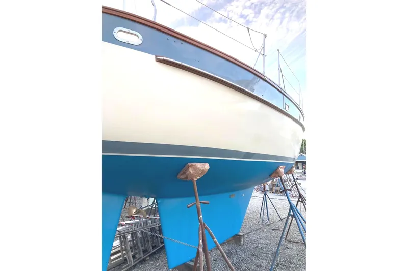 Slide: The Image of Bruce Roberts 35 sailboat from 1990 on stands, showcasing hull and deck details. - 54