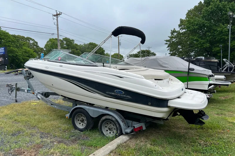 Slide: The Image of 2005 Chaparral 204 SSi boat on trailer, parked outdoors, with trees in the background. - 2