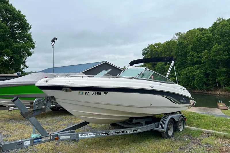 Slide: The Image of 2005 Chaparral 204 SSi boat on trailer near a lake, surrounded by trees. - 3
