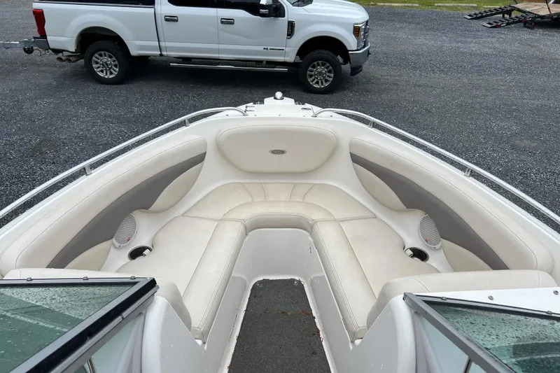 Slide: The Image of 2005 Chaparral 204 SSi boat interior with white seating, parked truck in background. - 5