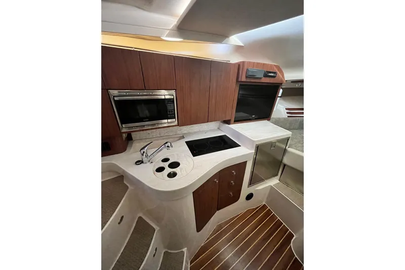 Slide: The Image of 2017 Grady-White Express 330 boat interior kitchen with modern appliances and wood cabinetry. - 11