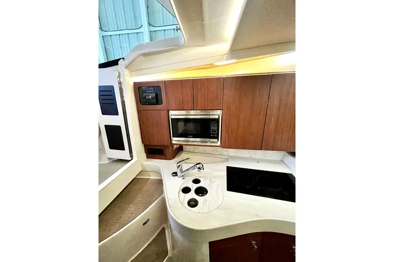 Slide: The Image of 2017 Grady-White Express 330 boat interior kitchen with microwave, sink, and stove. - 12