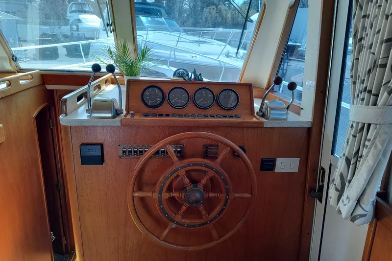 Slide: The Image of 2000 Mainship 390 Trawler helm with wooden steering wheel and control panel. - 11