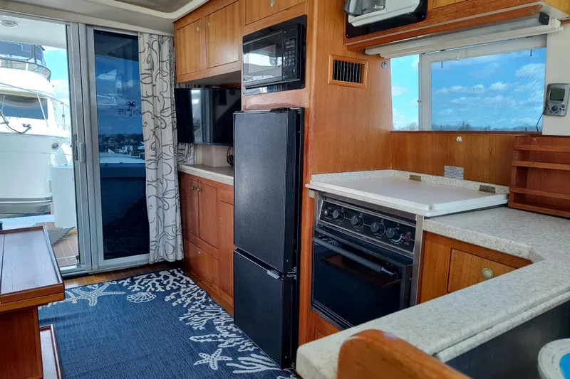Slide: The Image of Interior of 2000 Mainship 390 Trawler with kitchen, appliances, and nautical decor. - 14
