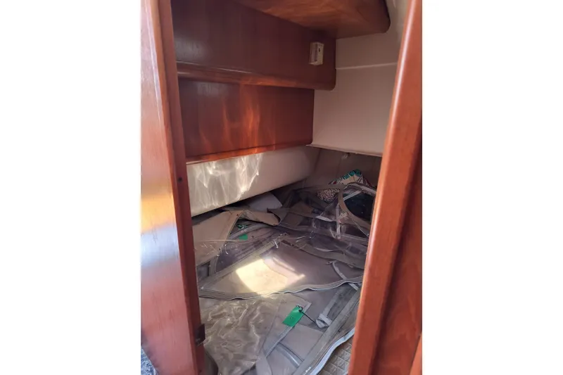 Slide: The Image of Interior cabin storage of 2000 Mainship 390 Trawler with wooden shelves and stored items. - 18