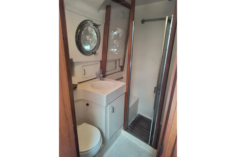 Slide: The Image of Bathroom interior of 2000 Mainship 390 Trawler with shower and porthole window. - 19