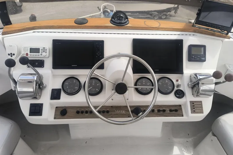 Slide: The Image of Helm of 2000 Mainship 390 Trawler with steering wheel, gauges, and navigation equipment. - 21