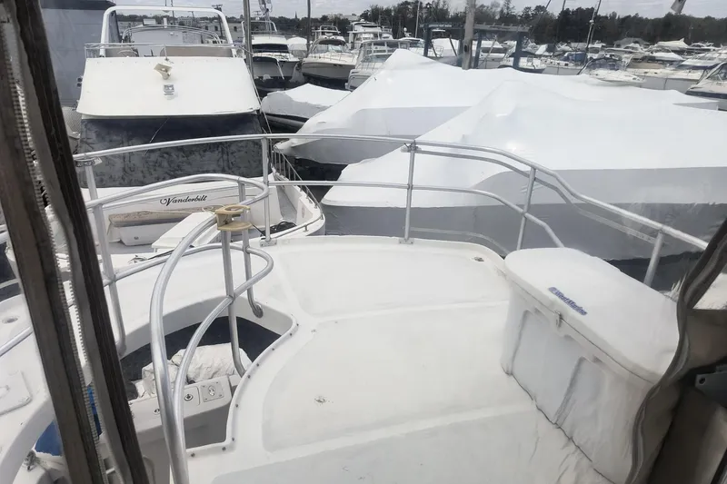 Slide: The Image of Mainship 390 Trawler 2000 docked among covered boats at a marina. - 24
