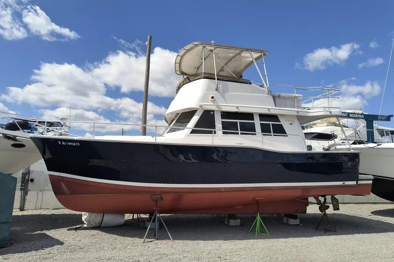 Slide: The Image of 2000 Mainship 390 Trawler on dry dock under a clear blue sky. - 3