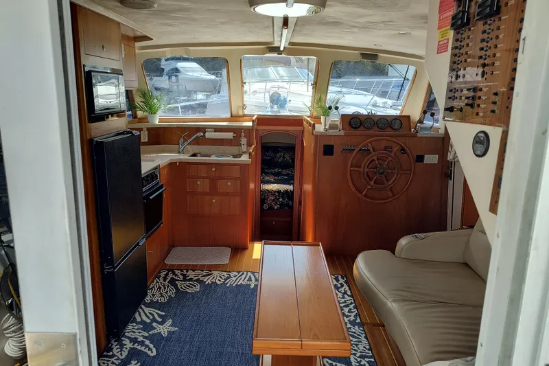 Slide: The Image of Interior of a 2000 Mainship 390 Trawler with helm, kitchenette, and seating area. - 4