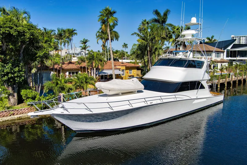 The Image of Luxury 2008 Viking 74 Enclosed Bridge yacht docked by tropical waterfront homes. - 1