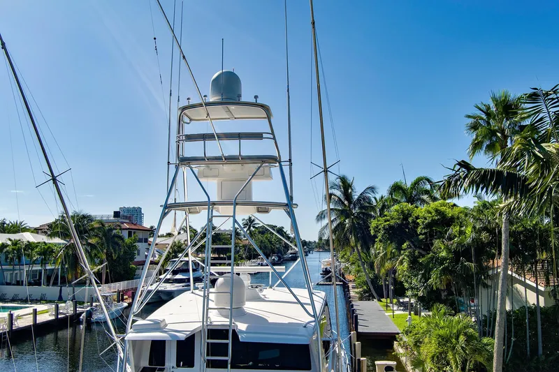 Slide: The Image of 2008 Viking 74 Enclosed Bridge yacht docked in a scenic, tropical marina setting. - 13