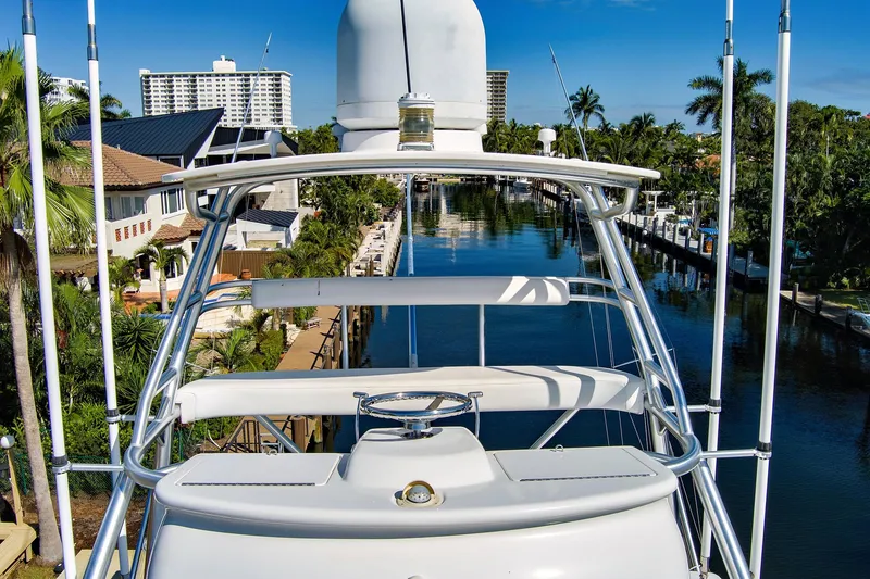 Slide: The Image of 2008 Viking 74 Enclosed Bridge yacht docked in a scenic canal with palm trees. - 16