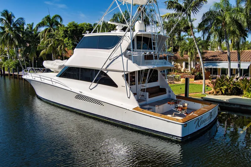Slide: The Image of 2008 Viking 74 Enclosed Bridge yacht docked by palm trees and waterfront home. - 4