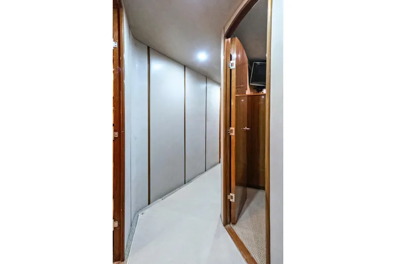 Slide: The Image of Interior hallway of 2008 Viking 74 Enclosed Bridge yacht, featuring wooden doors and modern lighting. - 48