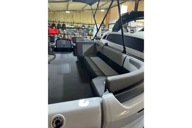 Slide: The Image of 2025 Manitou Cruise 22 Max Switchback interior with spacious seating in showroom. - 4