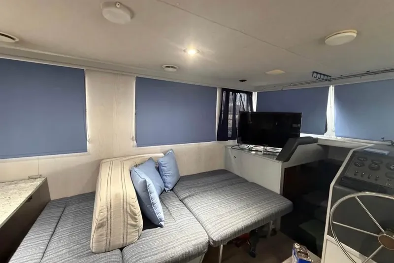 Slide: The Image of Interior of a 1996 Gibson Sport 41 boat with blue blinds and a cozy seating area. - 4